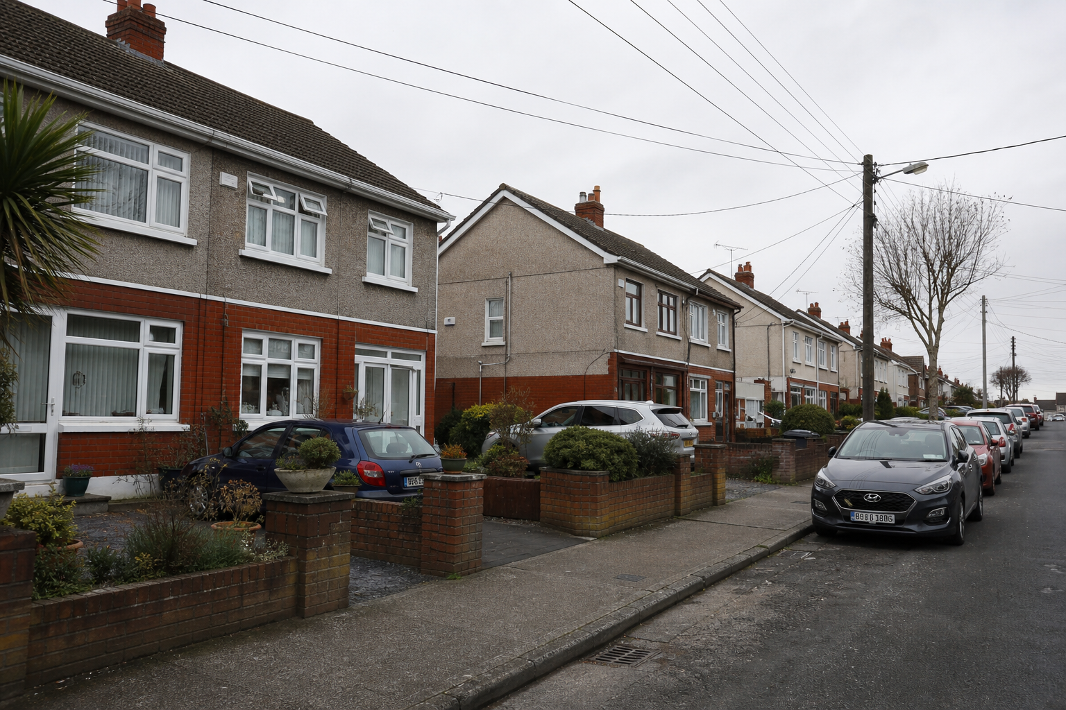 Mid-afternoon shot of Coolock Lane near the industrial estate — low-rise commercial units, sodium-lit shopfronts of Northside Shopping Centre in the distance